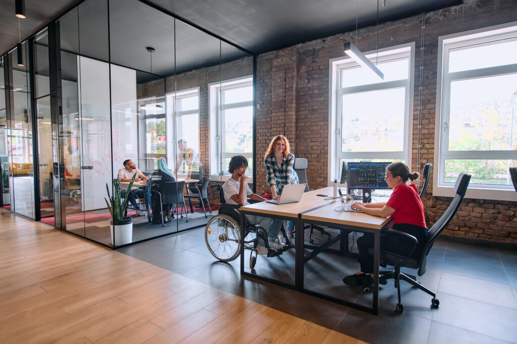 a diverse group of business professionals collaborates in a modern startup coworking center, utilizing a mix of paper based and technological tools such as mobile phones and computers