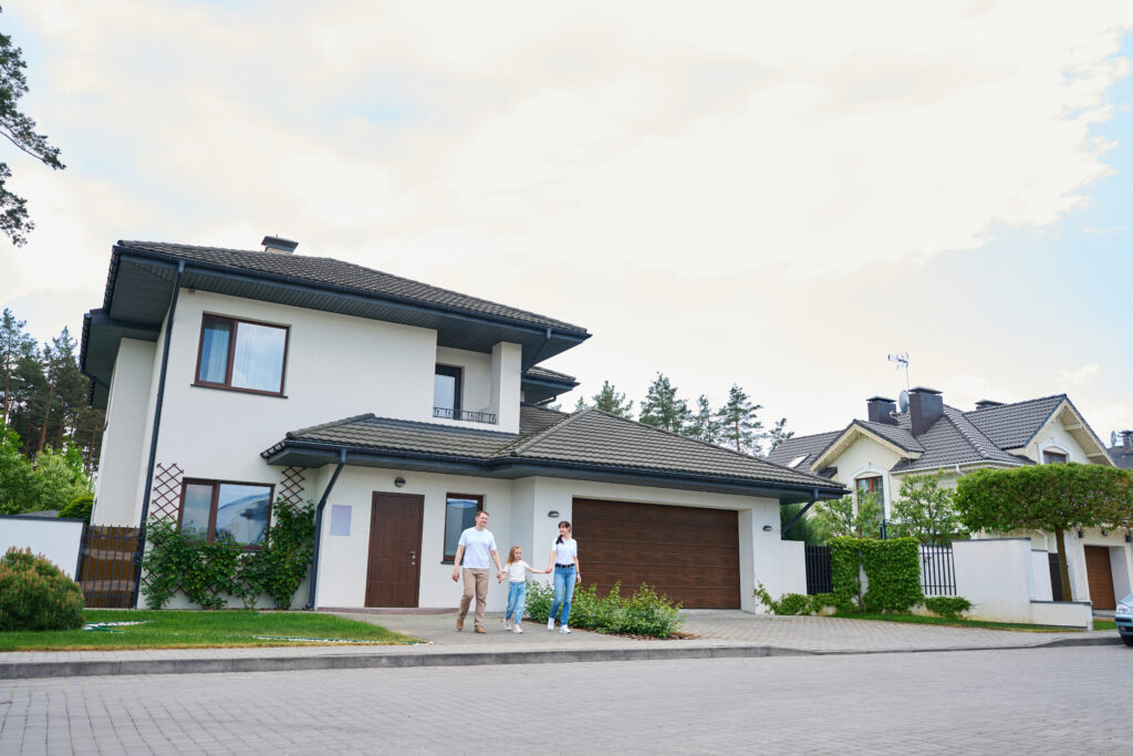 family going from new modern townhouse outdoors in warm cloudy day